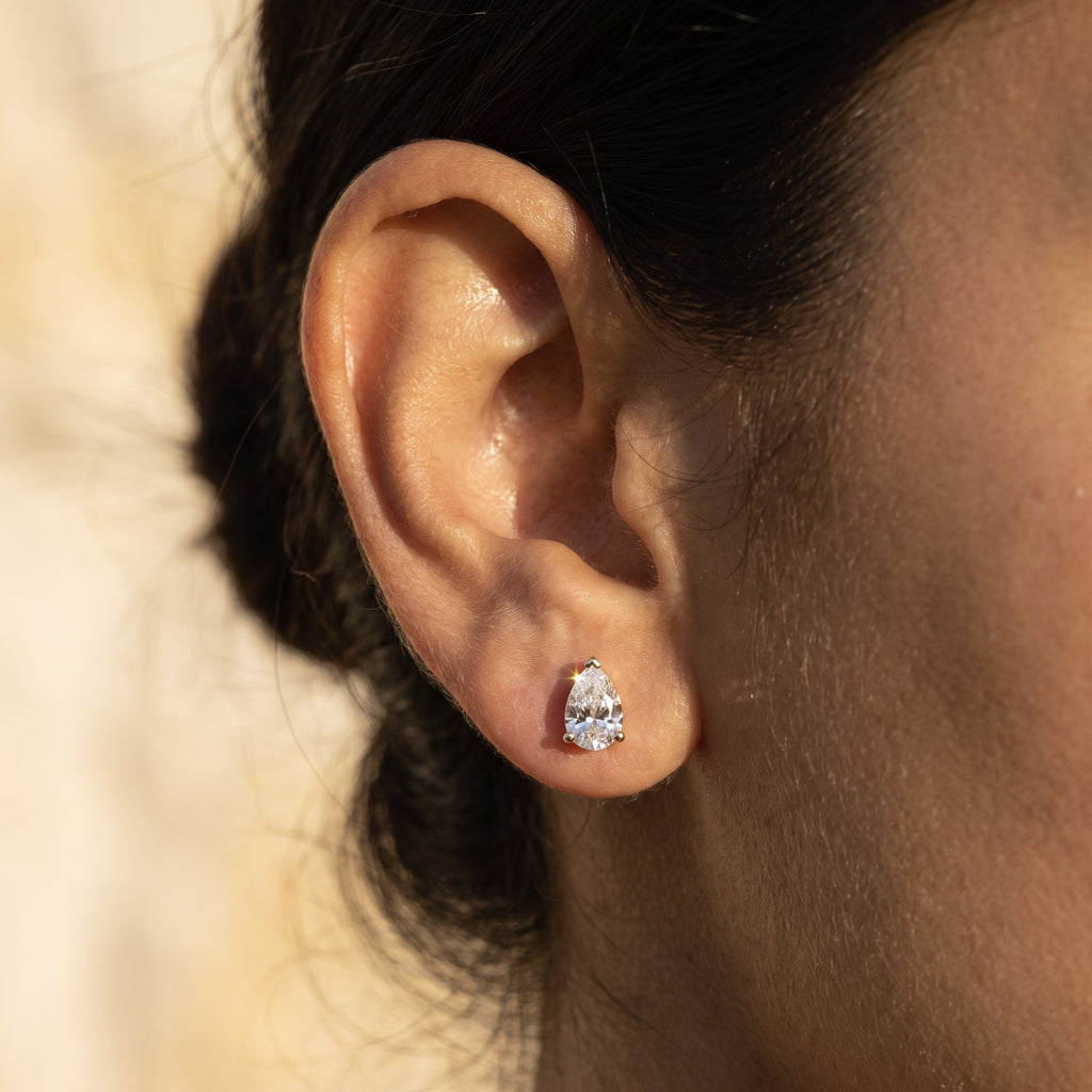 Leah's Tear one carat pear stud worn in the earlobe at true scale