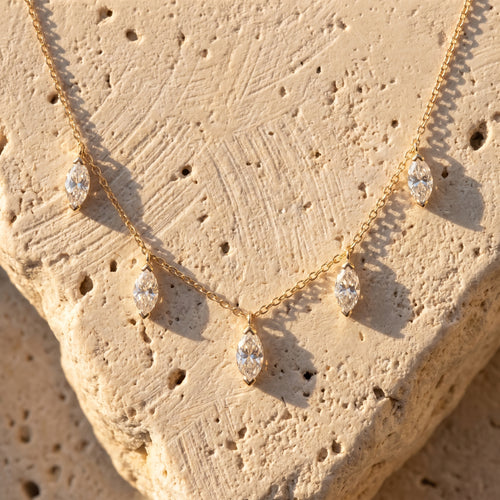Floating Marquise Diamond Necklace laid on raw Jerusalem limestone in late afternoon sun