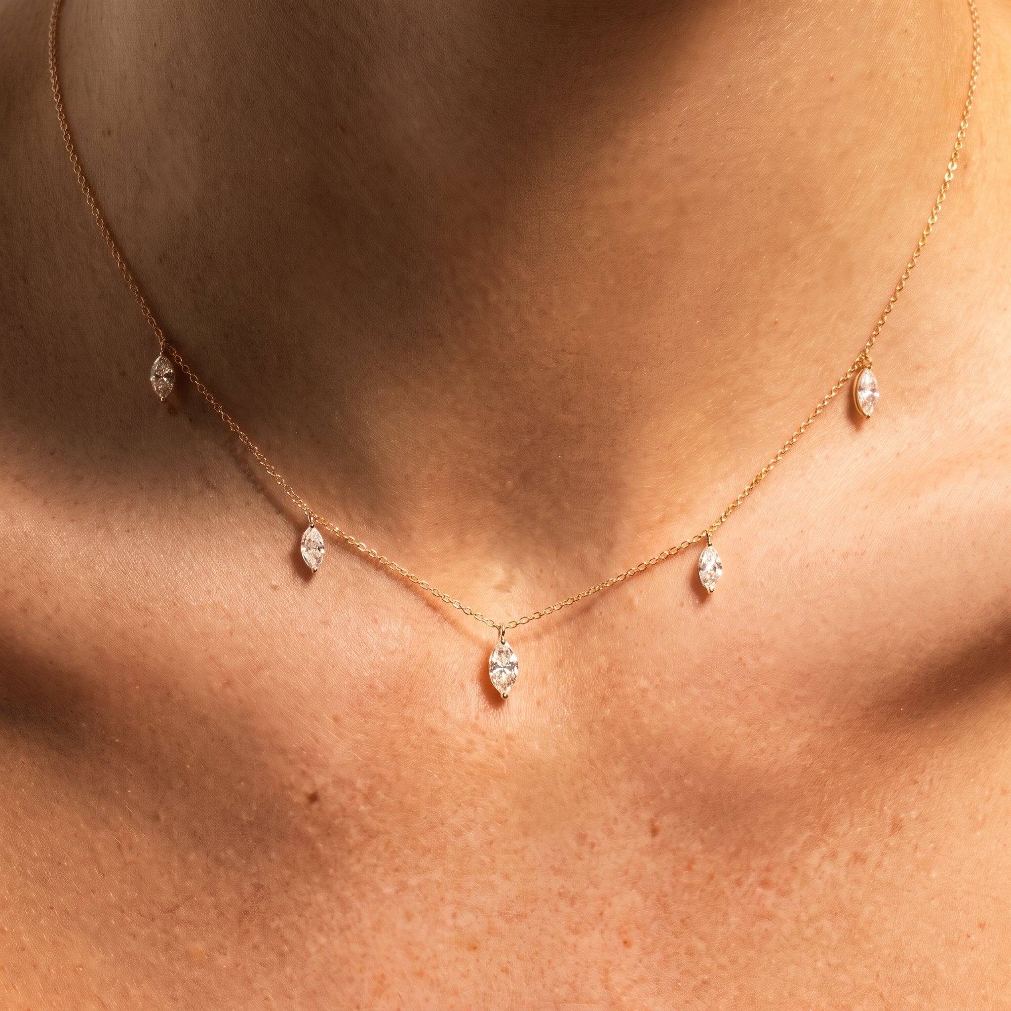 Floating Marquise Diamond Necklace worn at the collarbone in golden hour light