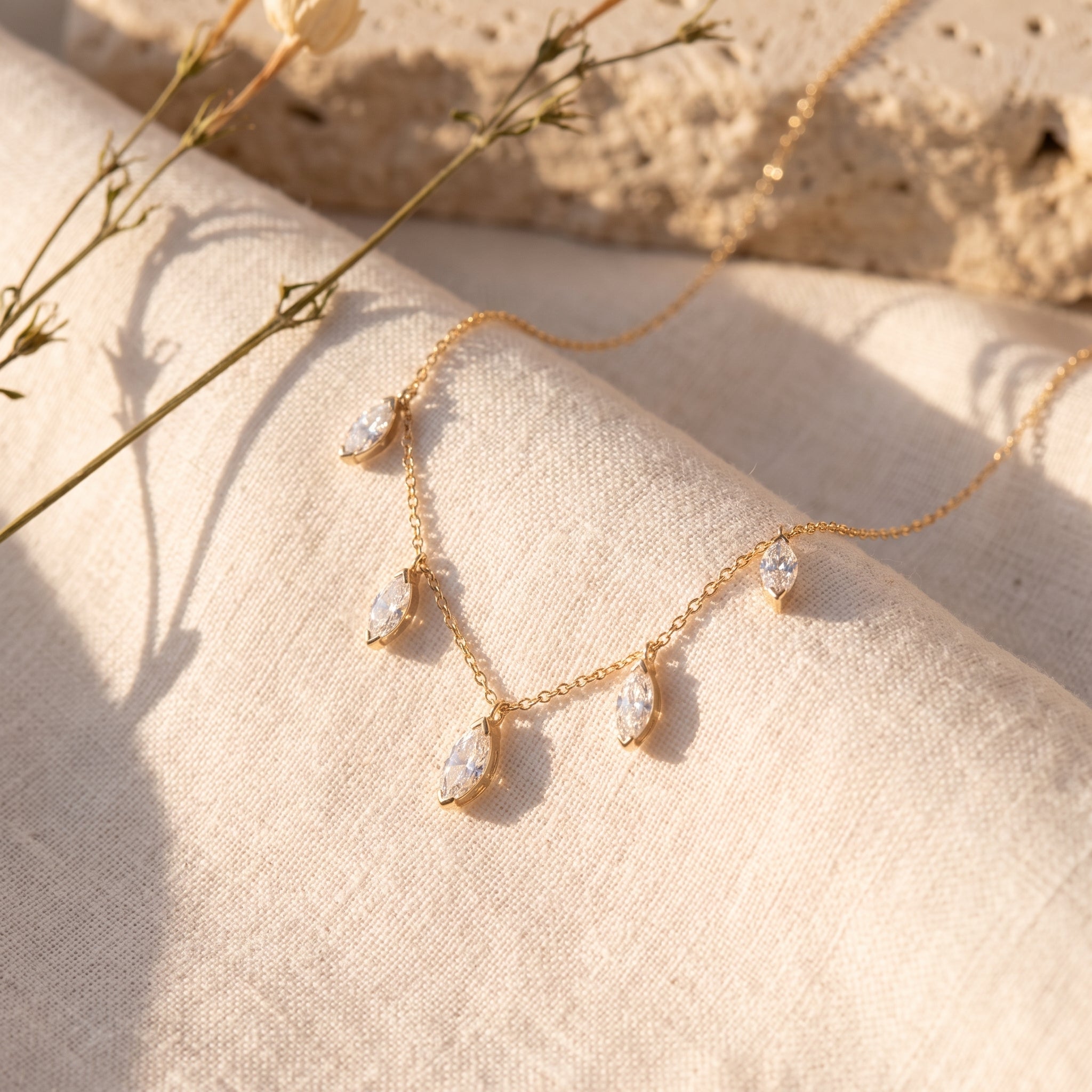 Floating Marquise Diamond Necklace on raw linen with dried stems and Jerusalem stone