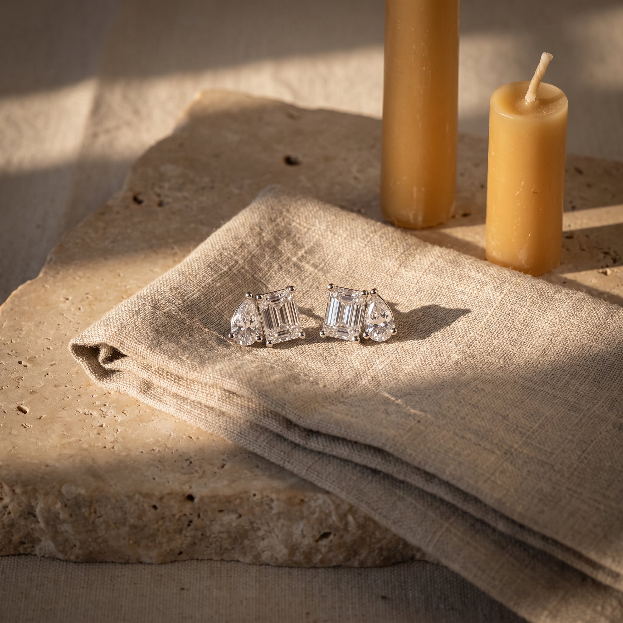 Toi et moi diamond studs still life on raw linen with beeswax tapers on Jerusalem stone