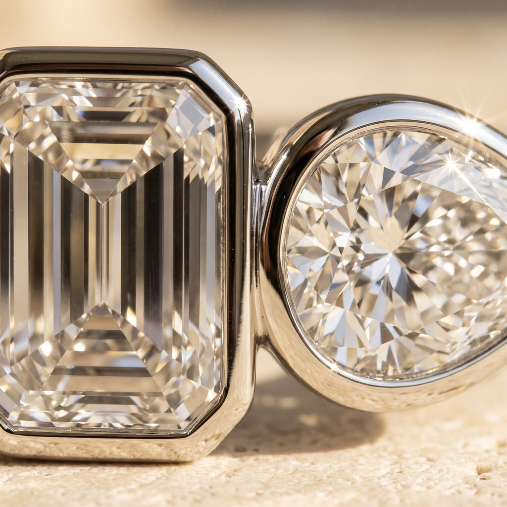 Macro detail of Rachel's Vow Ring: step-cut emerald facets and pear brilliance meeting at the touching bezels