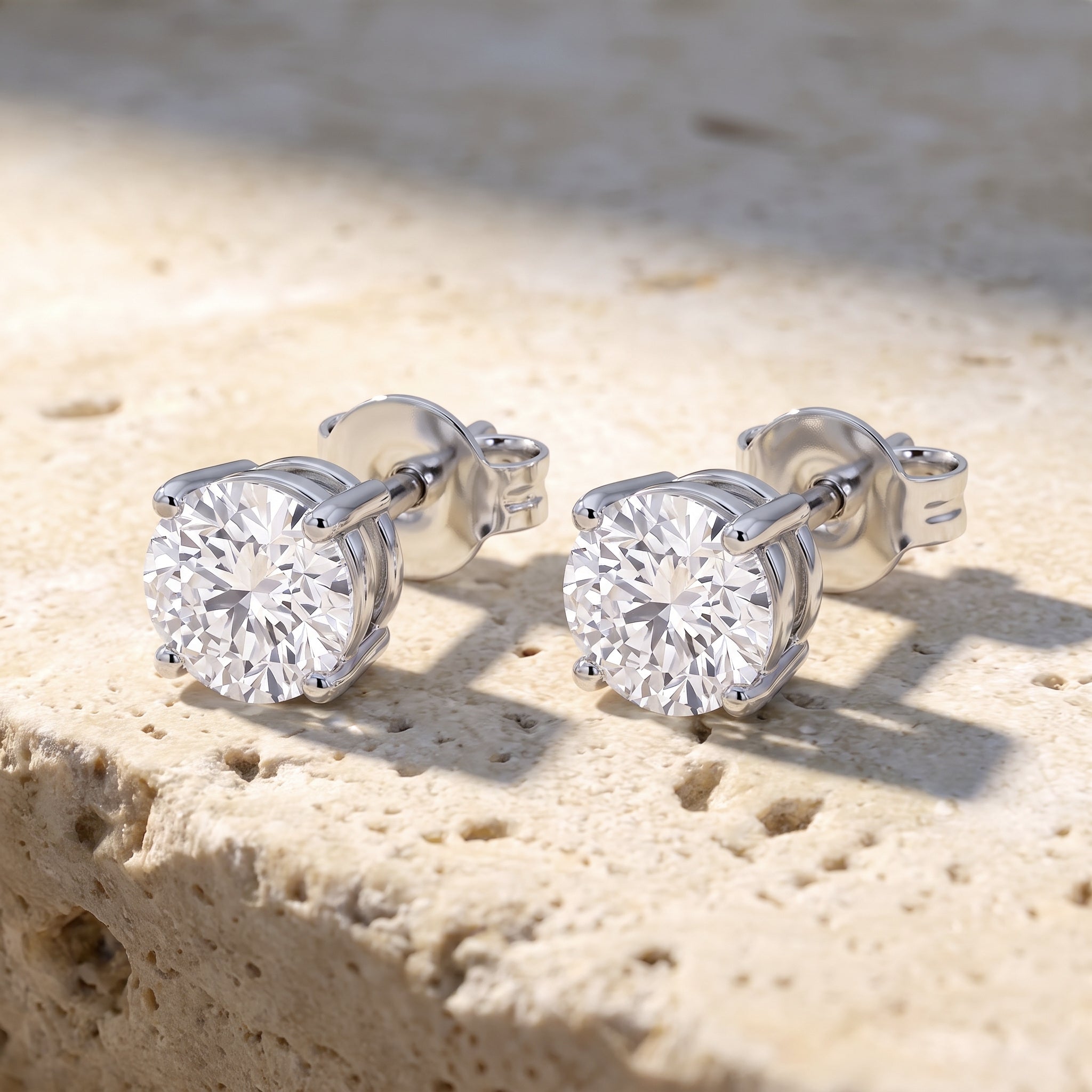 Sarah's Light solitaire round brilliant diamond studs in 14k white gold, four-prong basket setting, on raw Jerusalem stone