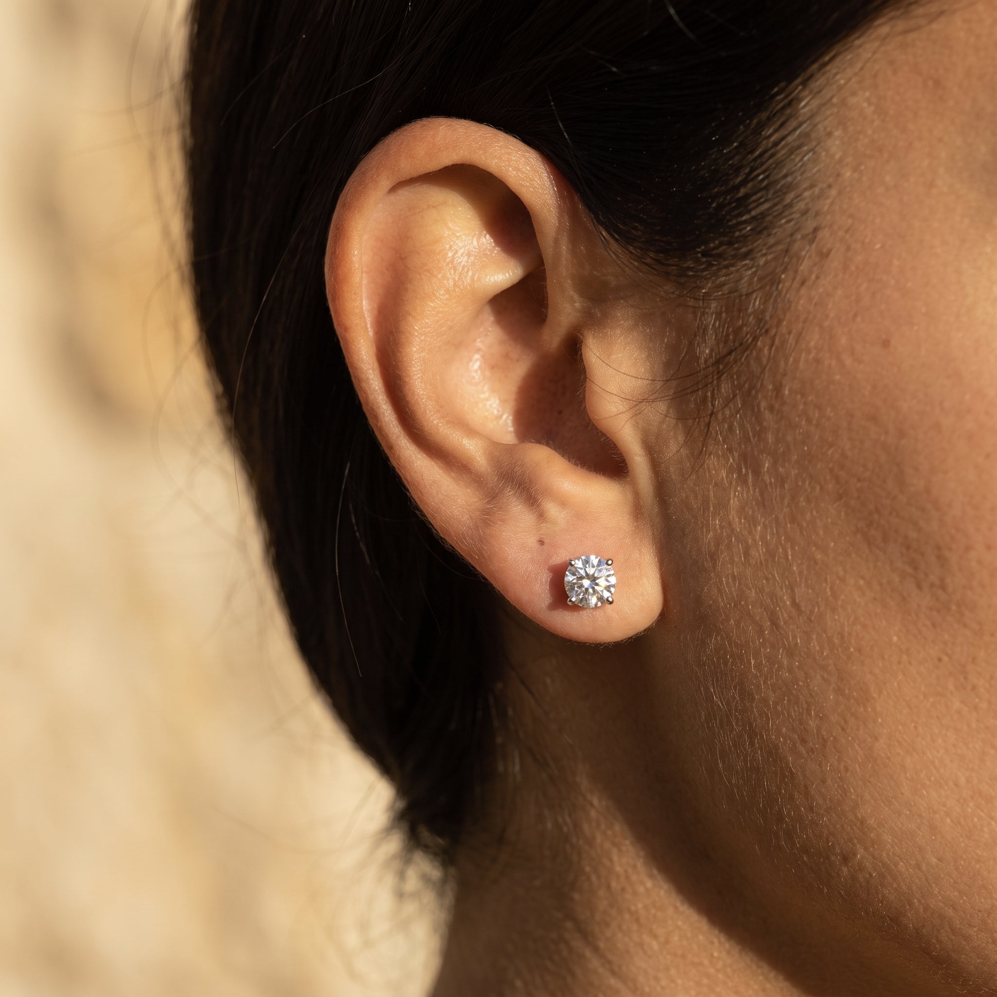 Sarah's Light one carat diamond stud worn in the earlobe, shown at true scale