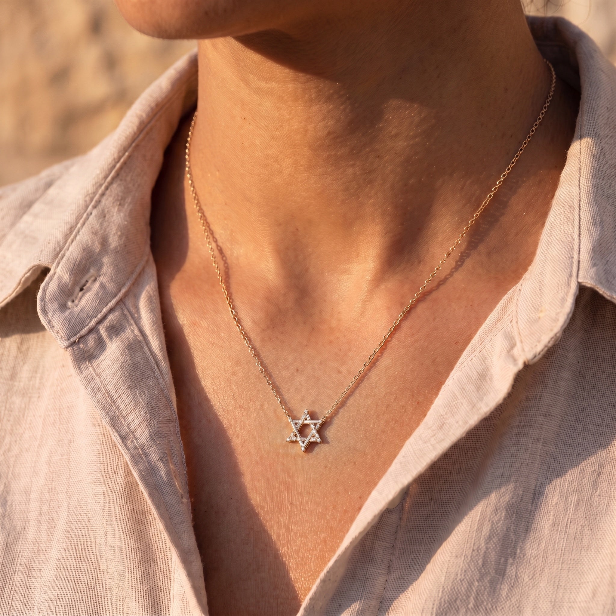 The Magen David Necklace worn at the collar in golden-hour light